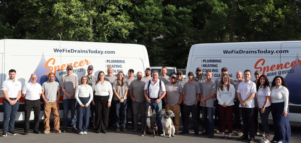 The Spencer Home Services team in Peabody in front of branded service vans