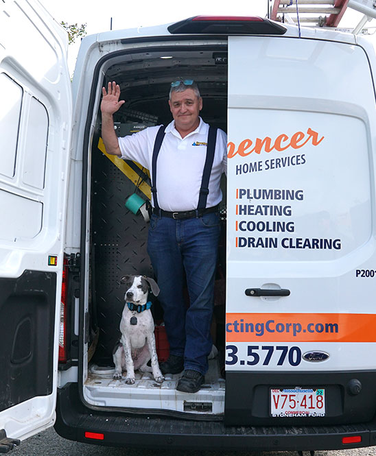 Spencer Home Services Owner, Peter Holland standing in a company van with his dog in Peabody MA.