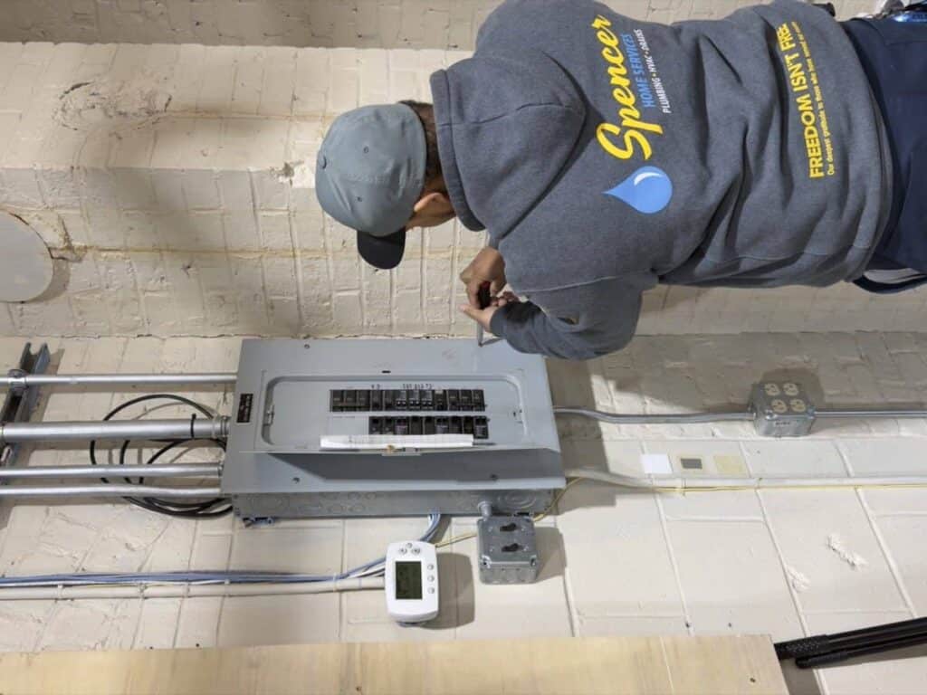 Spencer electrician working at an electrical panel